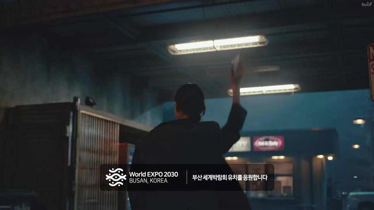 a man standing in a parking garage holding his hands up