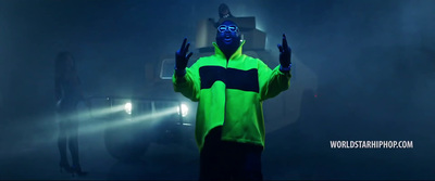 a man in a neon green jacket standing in a dark room