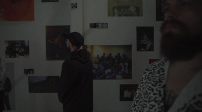 a man standing in front of a wall with pictures on it