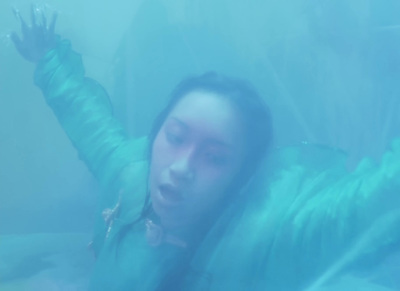 a woman in a green jacket is floating in the water