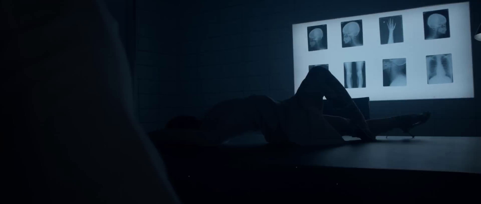 a person laying on a desk in a dark room