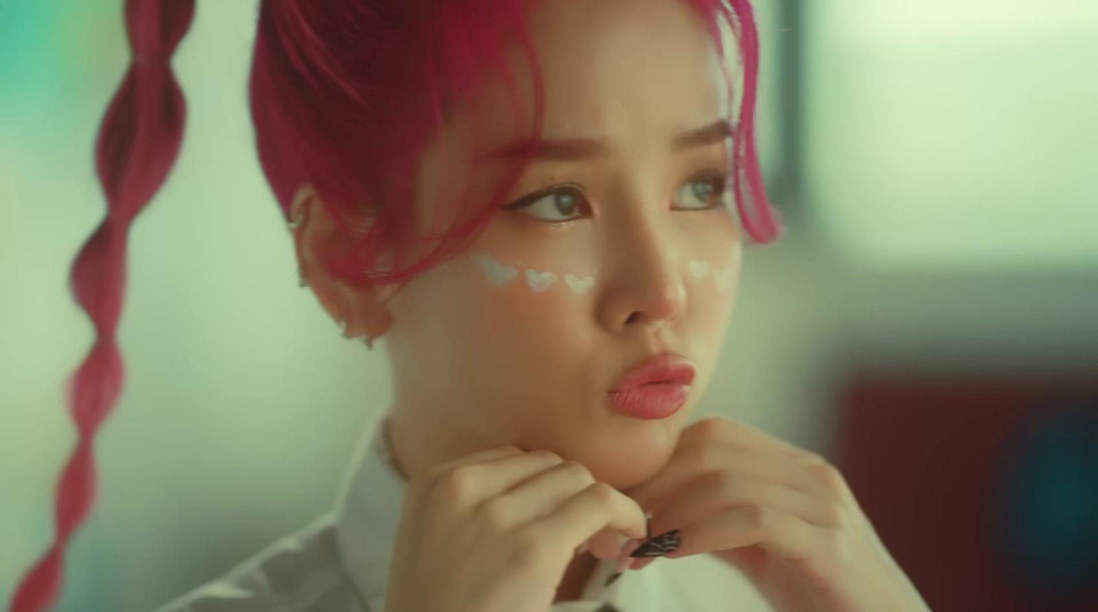 a woman with pink hair and white makeup