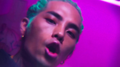 a man with green hair and piercings making a face