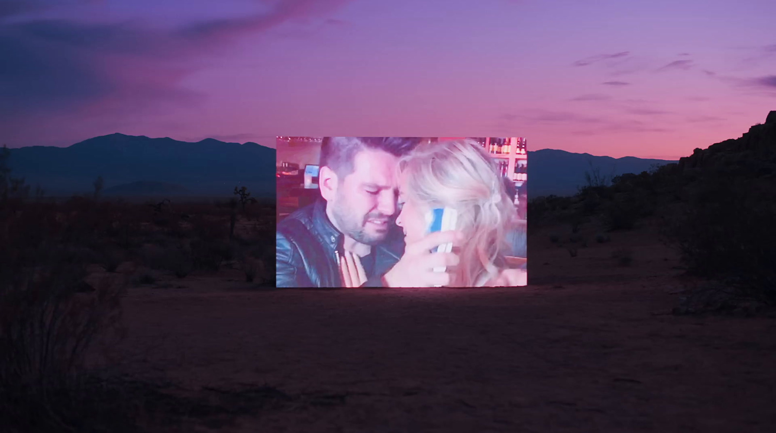 a man and a woman standing in front of a screen