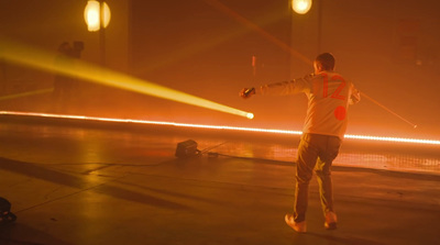 a man standing in a parking lot holding a light saber