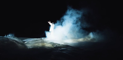 a person standing in the middle of a cloud of smoke