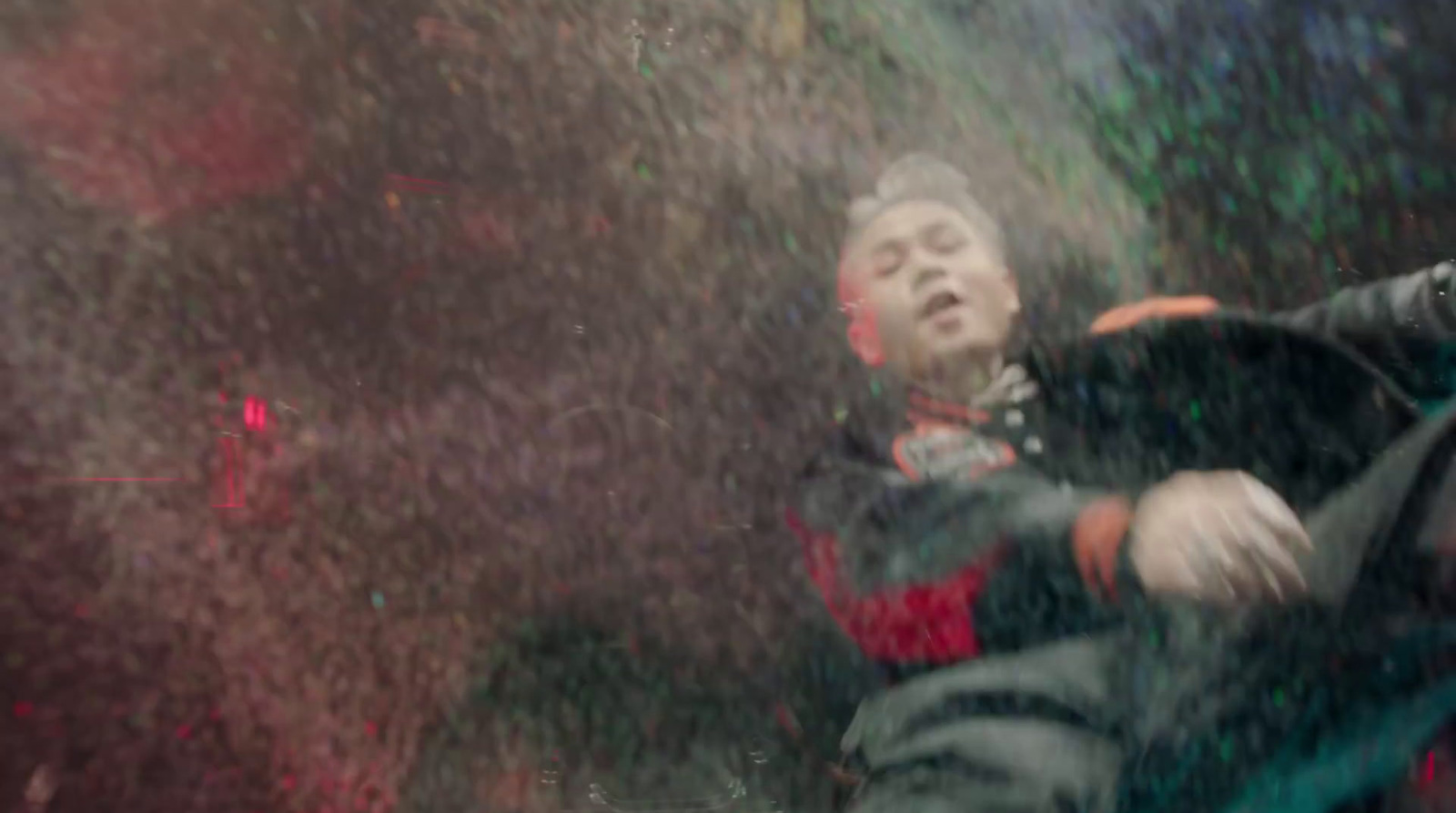 a young boy sitting on a bench in the rain