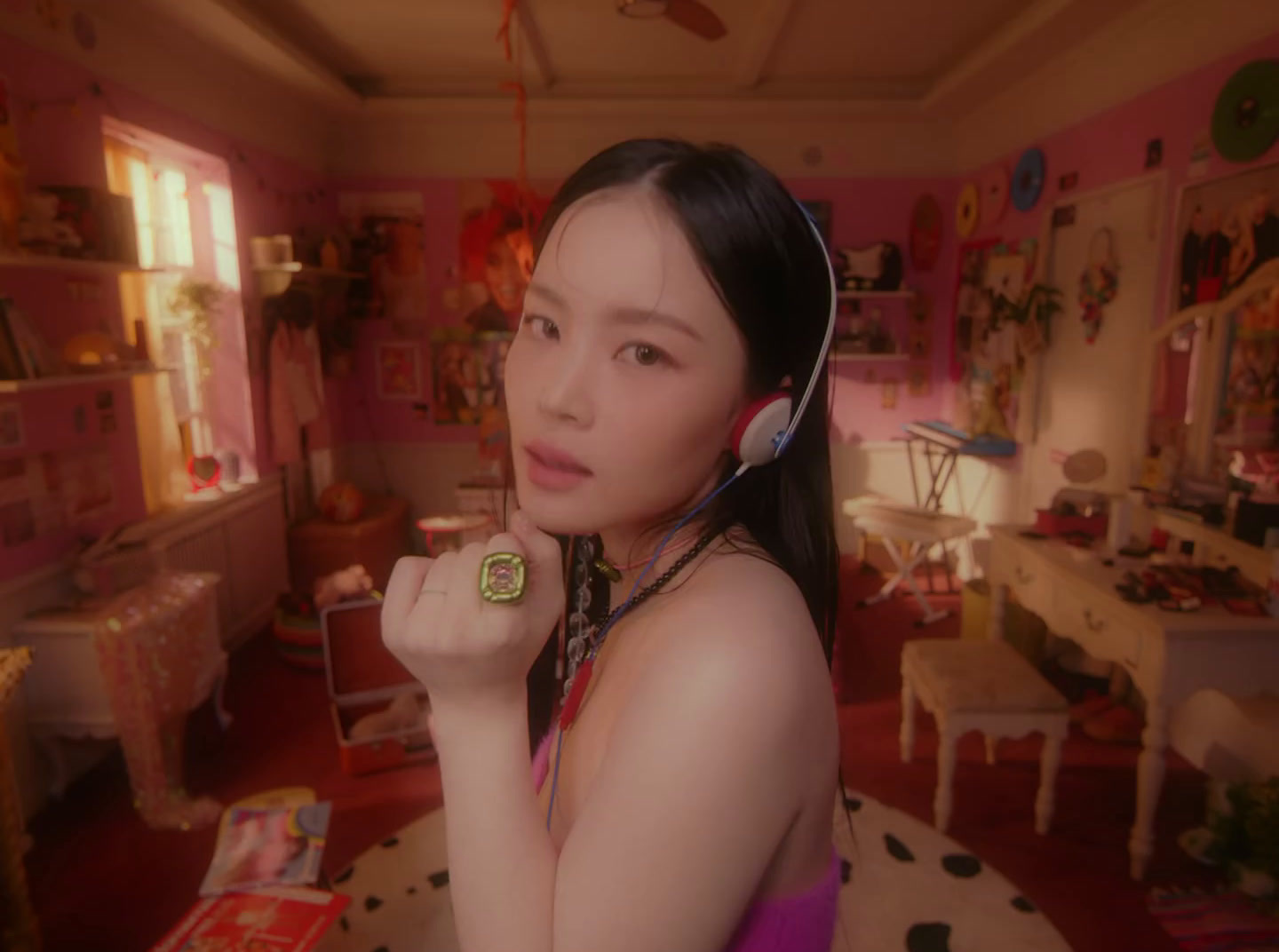 a woman wearing headphones in a pink room