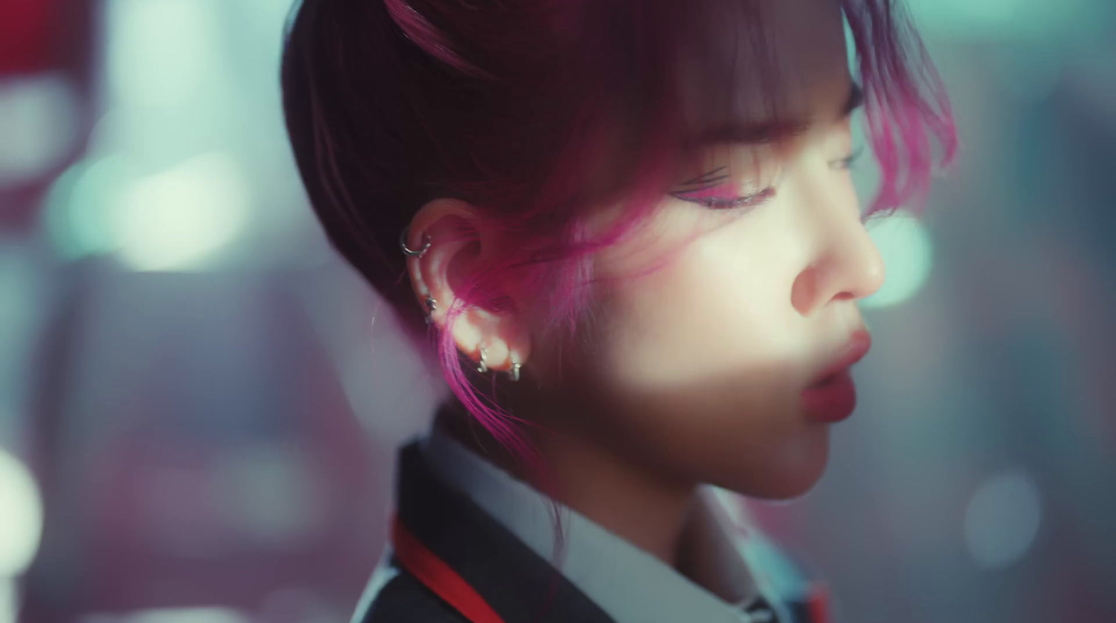 a woman with pink hair and ear piercings