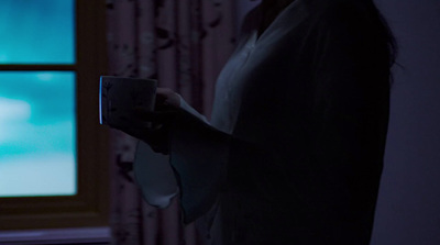 a woman holding a remote control in a dark room