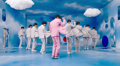 a man in a pink suit standing in front of a group of people