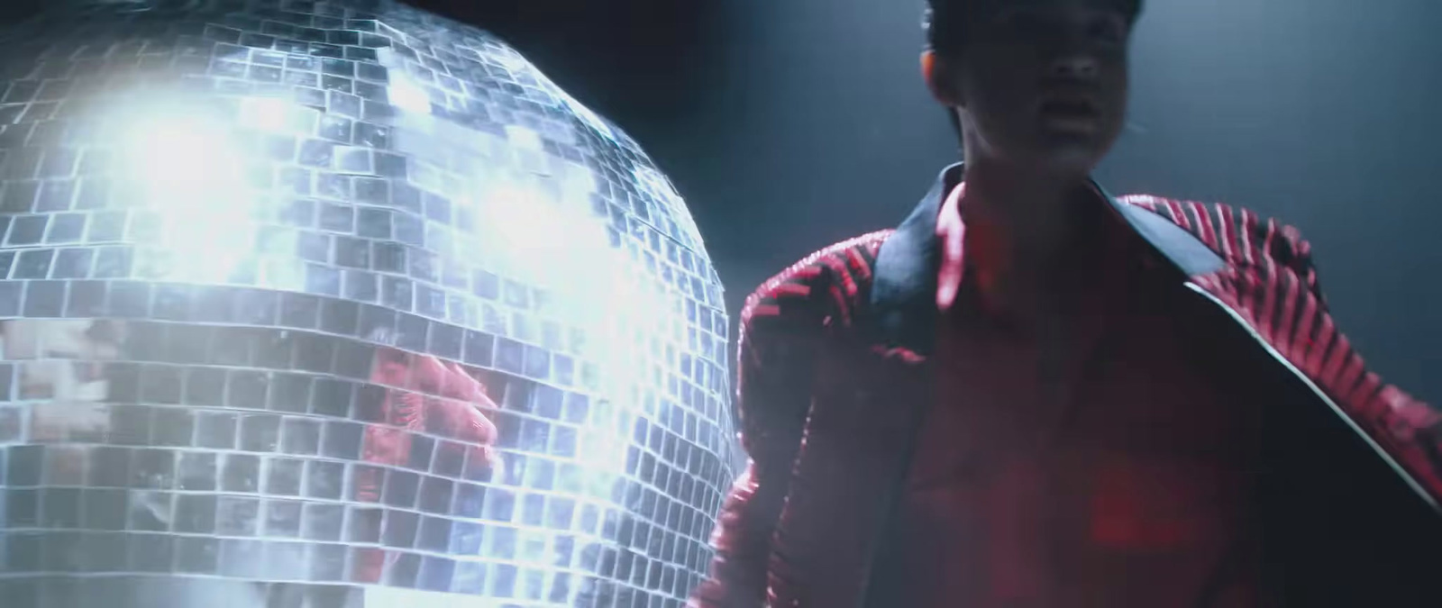 a man standing in front of a disco ball