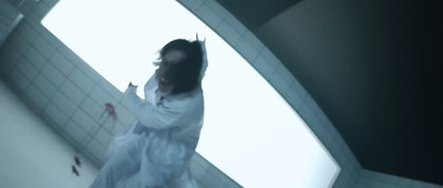 a woman in a white dress standing in a bathroom