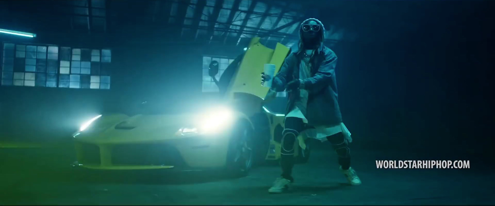 a man standing next to a yellow sports car