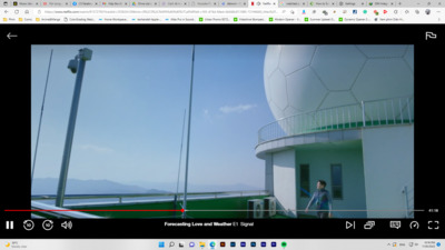 a person standing on a balcony next to a building