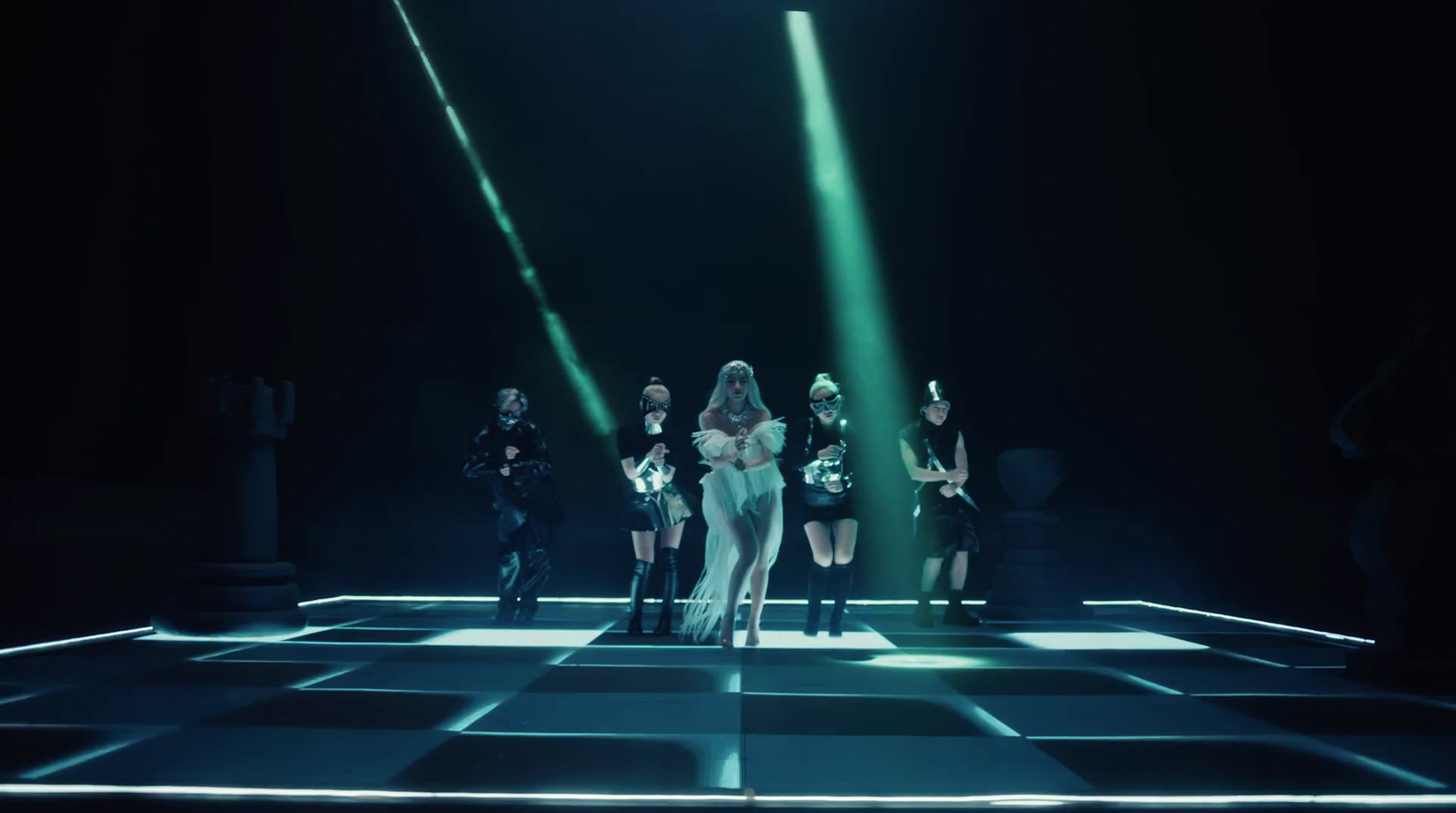 a group of women standing on top of a checkered floor