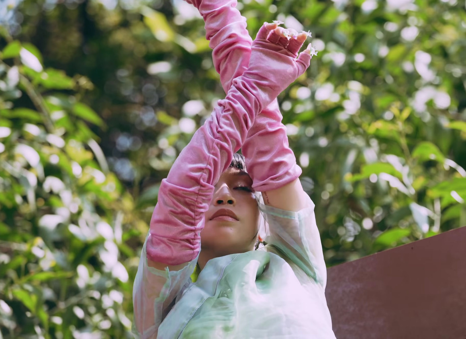 a woman in a white shirt and pink gloves