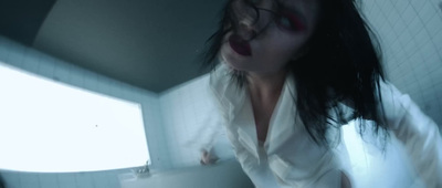 a woman in a white shirt and glasses in a bathroom