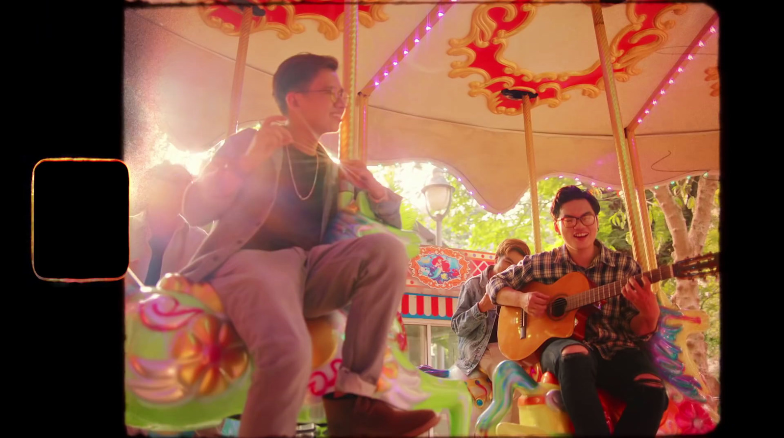 a man playing a guitar on a merry go round