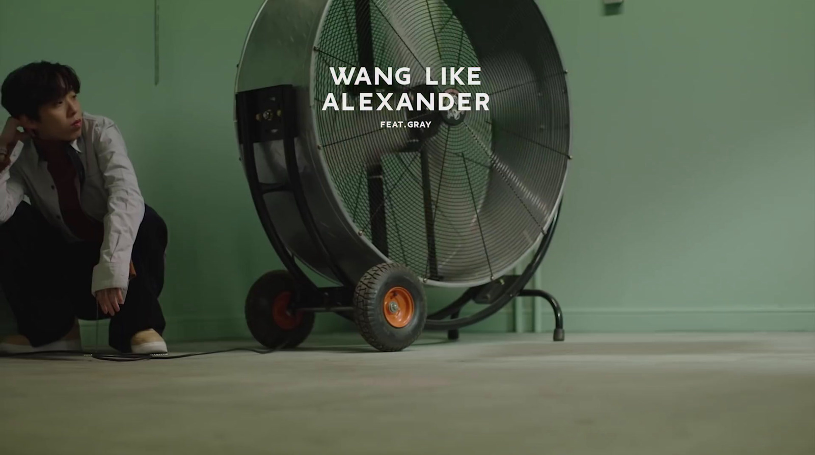 a man kneeling down next to a fan