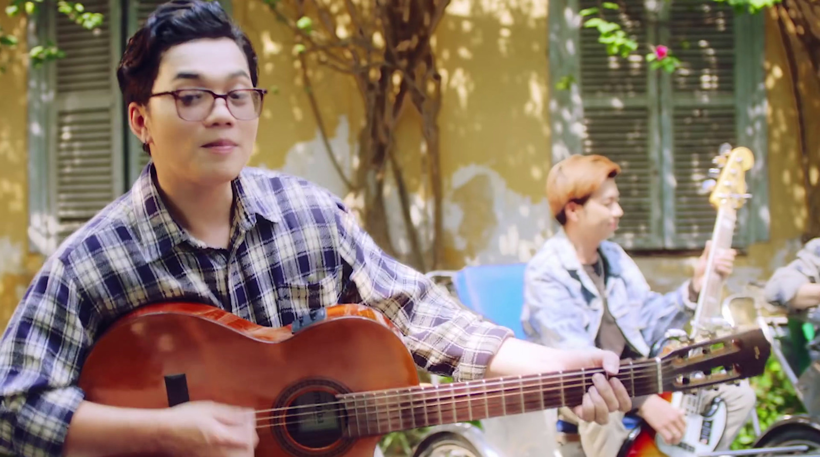 a man playing a guitar in front of a group of people