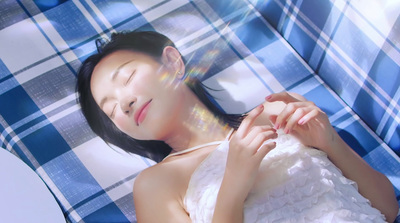 a woman in a white dress laying on a blue and white checkered blanket