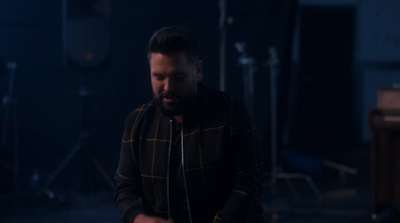 a man standing in front of a microphone in a dark room