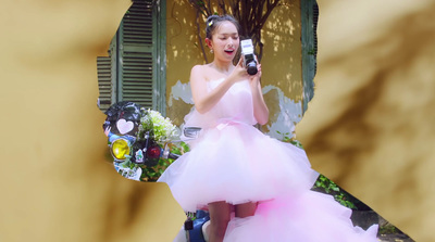 a woman in a pink dress holding a cell phone