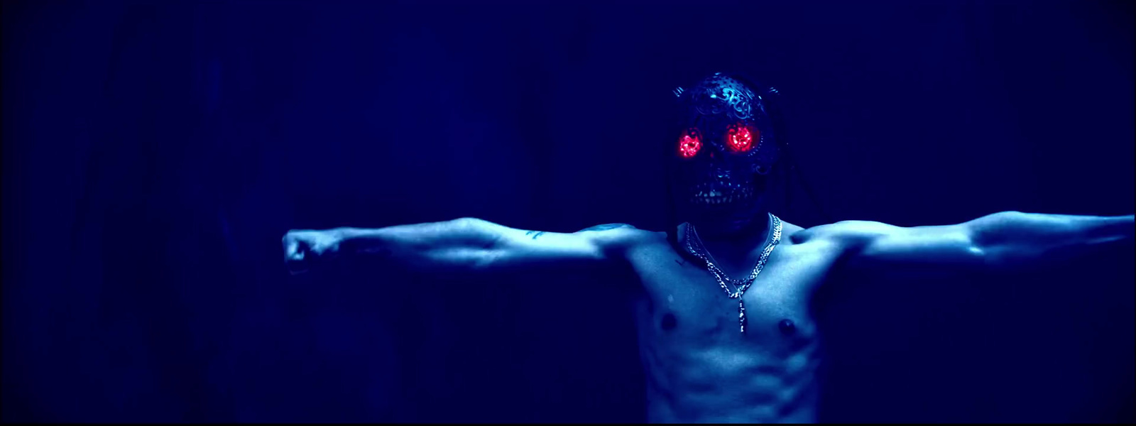 a shirtless man with red eyes and a cross on his chest