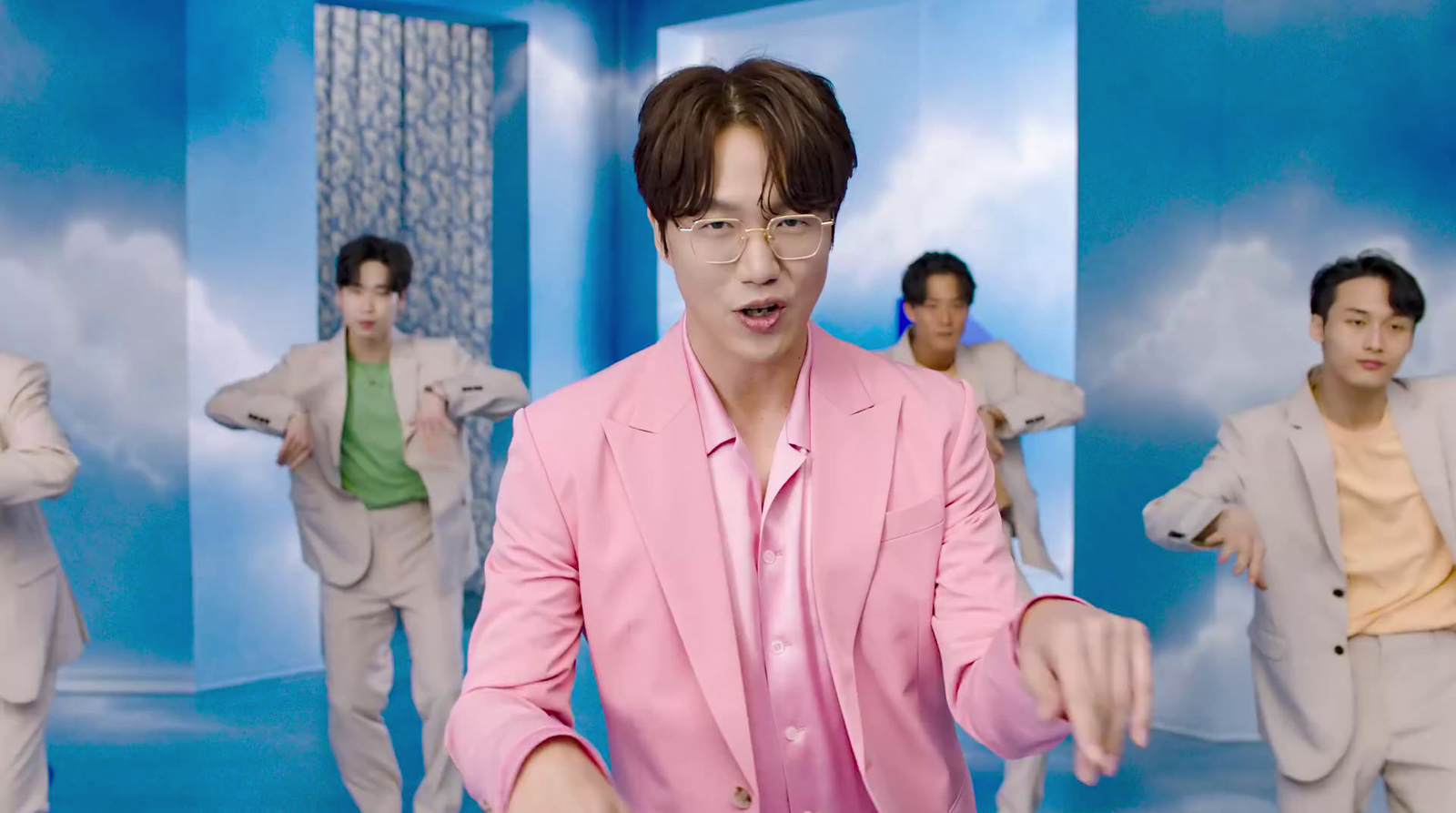 a man in a pink suit standing in front of a group of other men