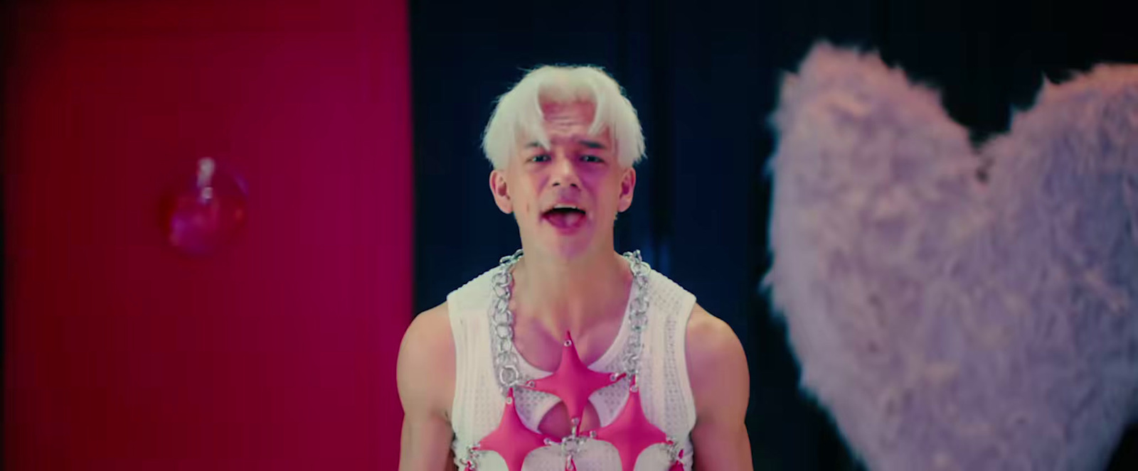 a man with white hair wearing a pink and white outfit