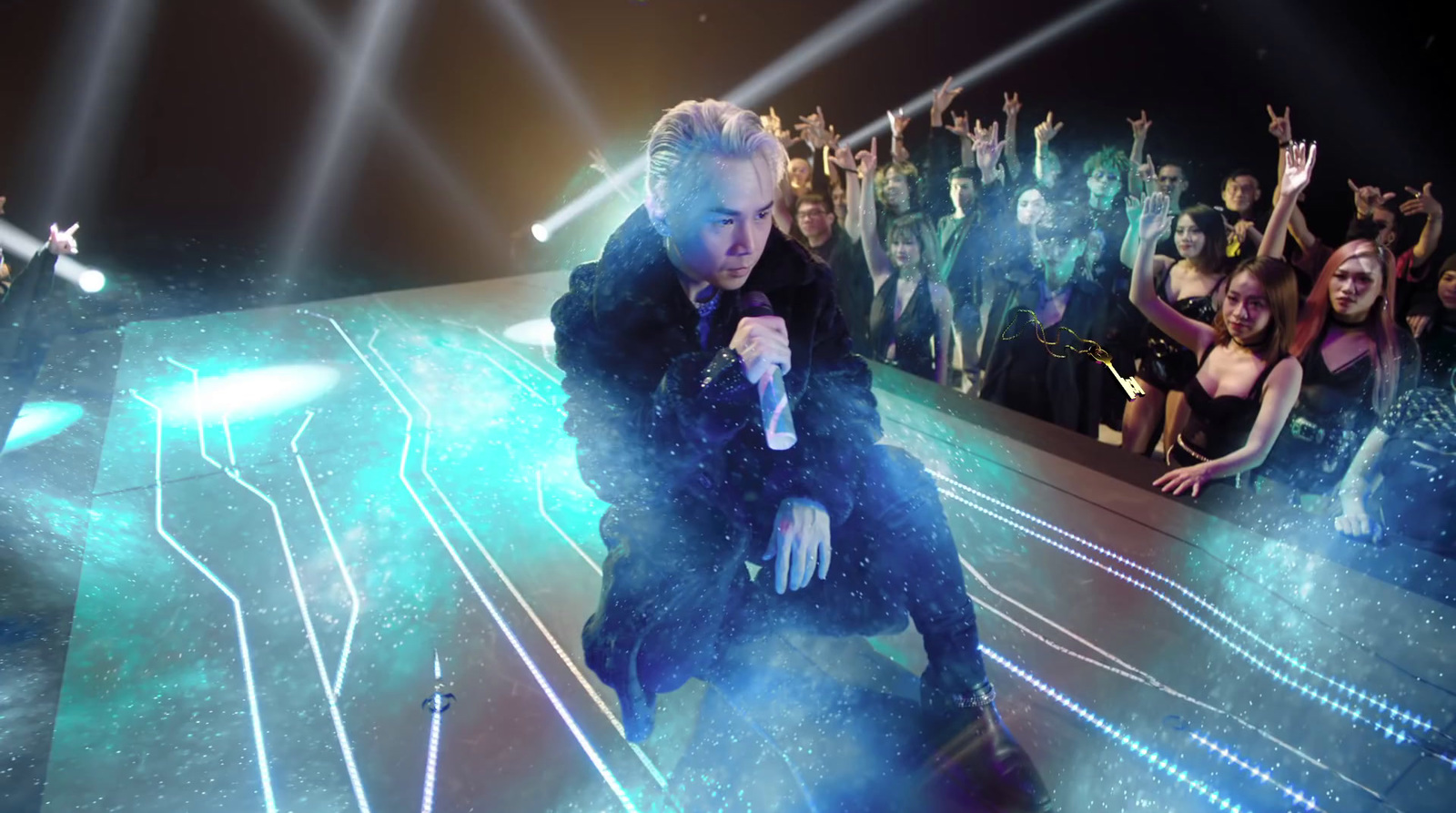 a man sitting on top of a floor in front of a crowd of people