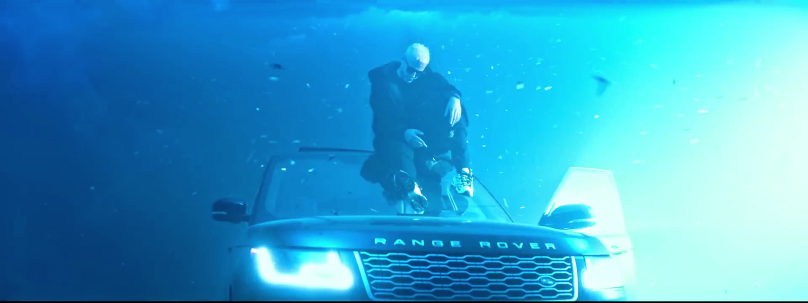 a man standing on top of a vehicle under water