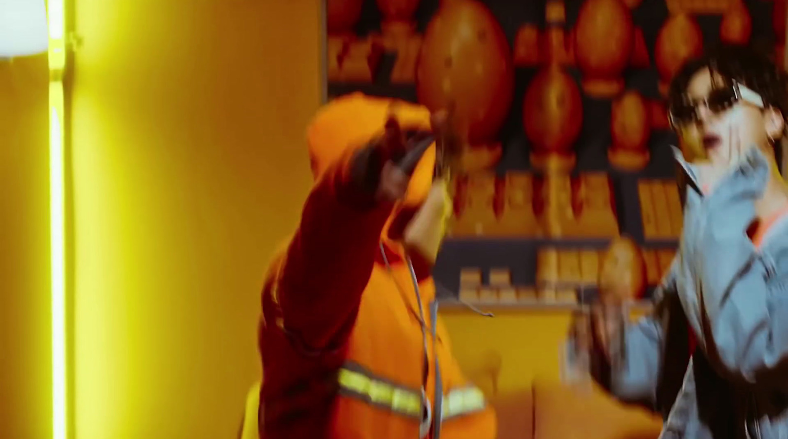 a man in an orange jacket is talking on a cell phone