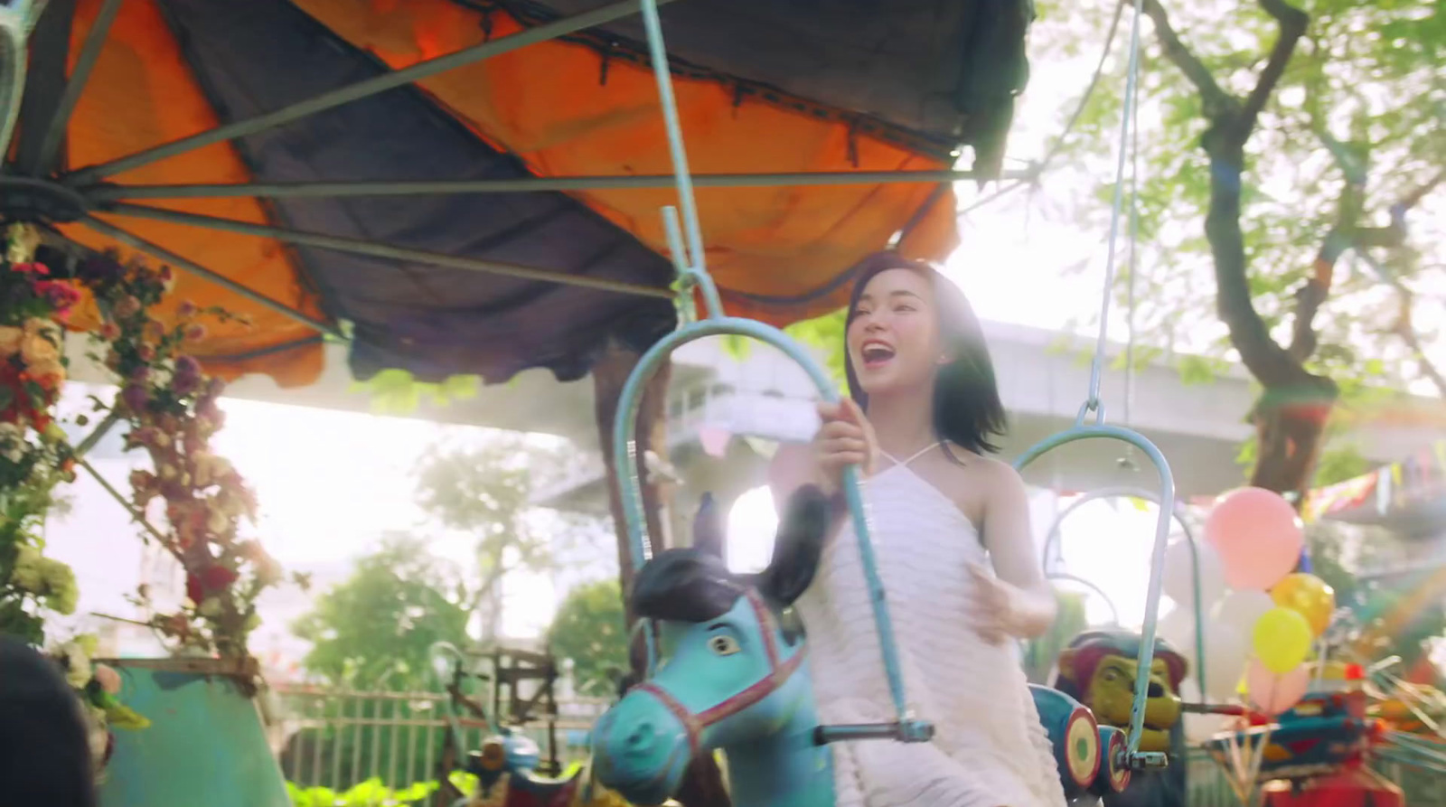 a woman in a white dress on a carousel