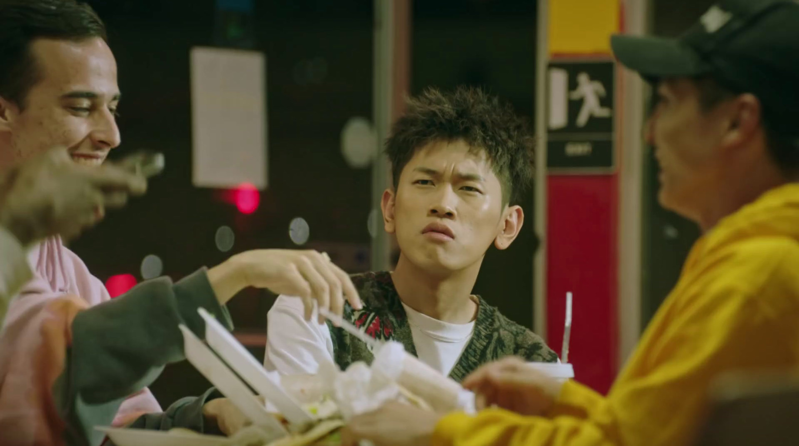 a group of men sitting around a table eating food