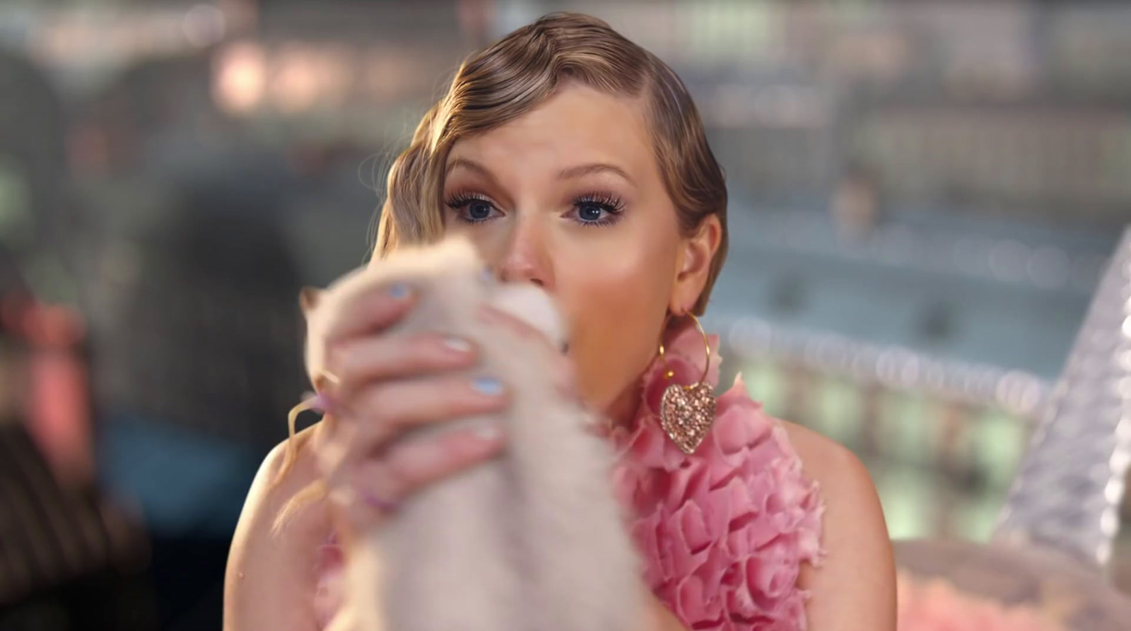 a woman in a pink dress holding a cat