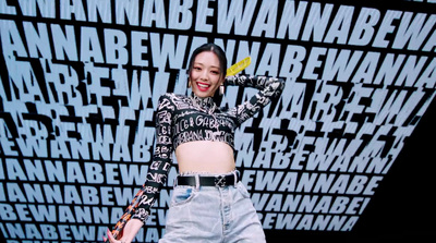 a woman standing in front of a wall with words on it