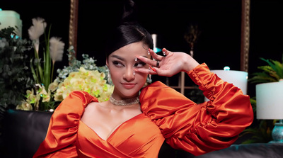 a woman in an orange dress posing for a picture