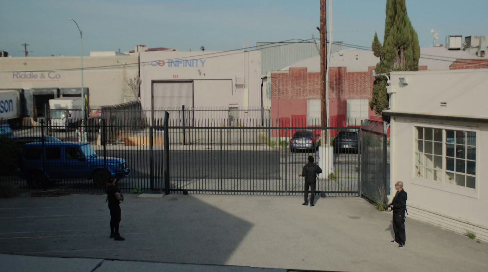 a couple of men standing in front of a fence