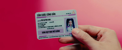 a person holding up a fake id card