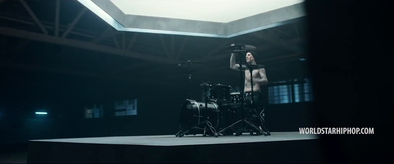 a woman standing on top of a stage next to a drum set