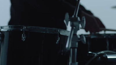 a man playing drums in a dark room