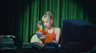 a woman sitting at a table with a book and a stuffed animal