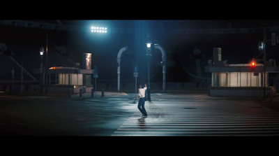 a man walking across a cross walk at night