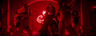 a group of women in costumes standing in front of a red light