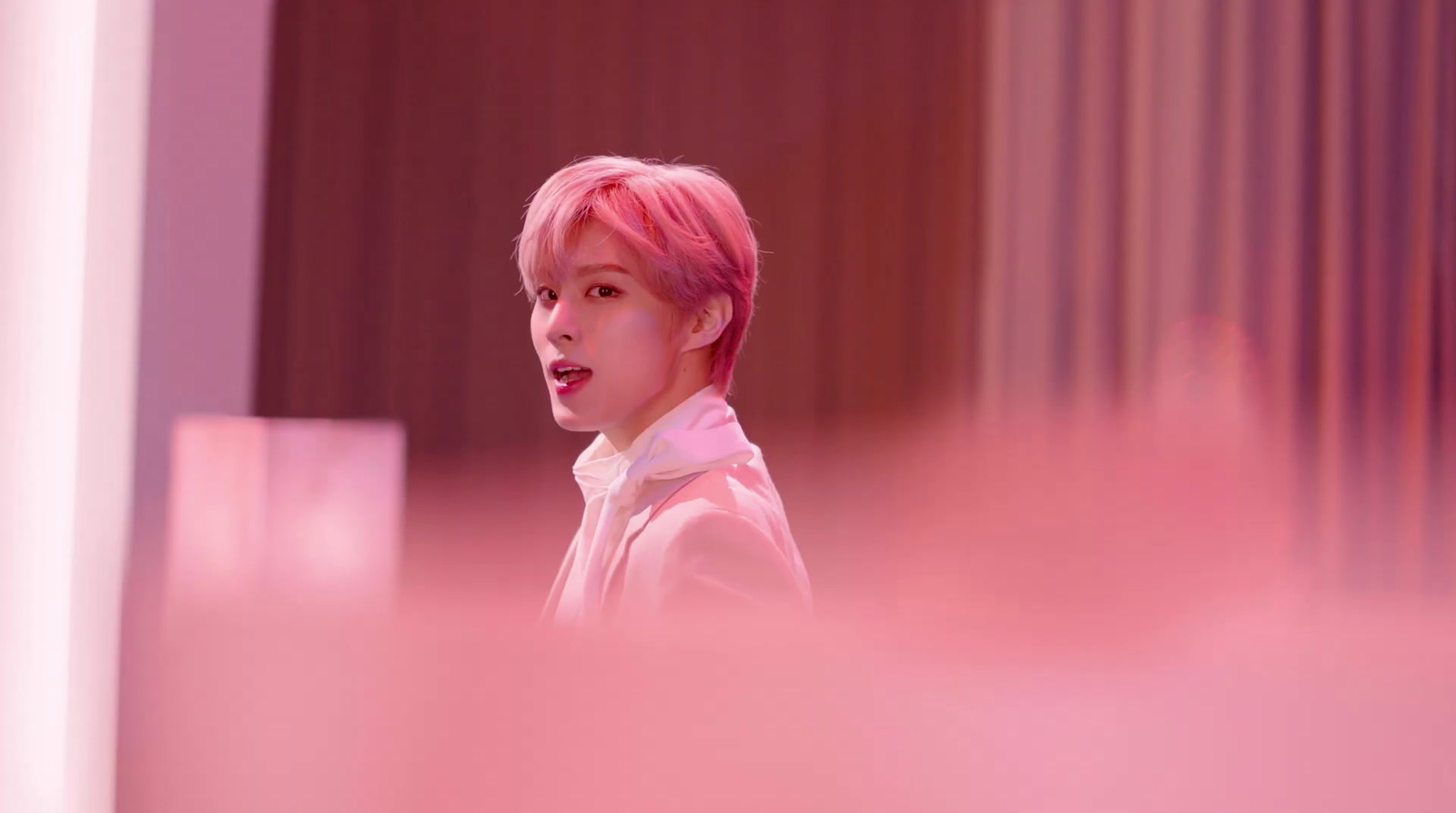 a person with pink hair and a white shirt