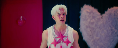 a man with white hair and a pink heart on his chest