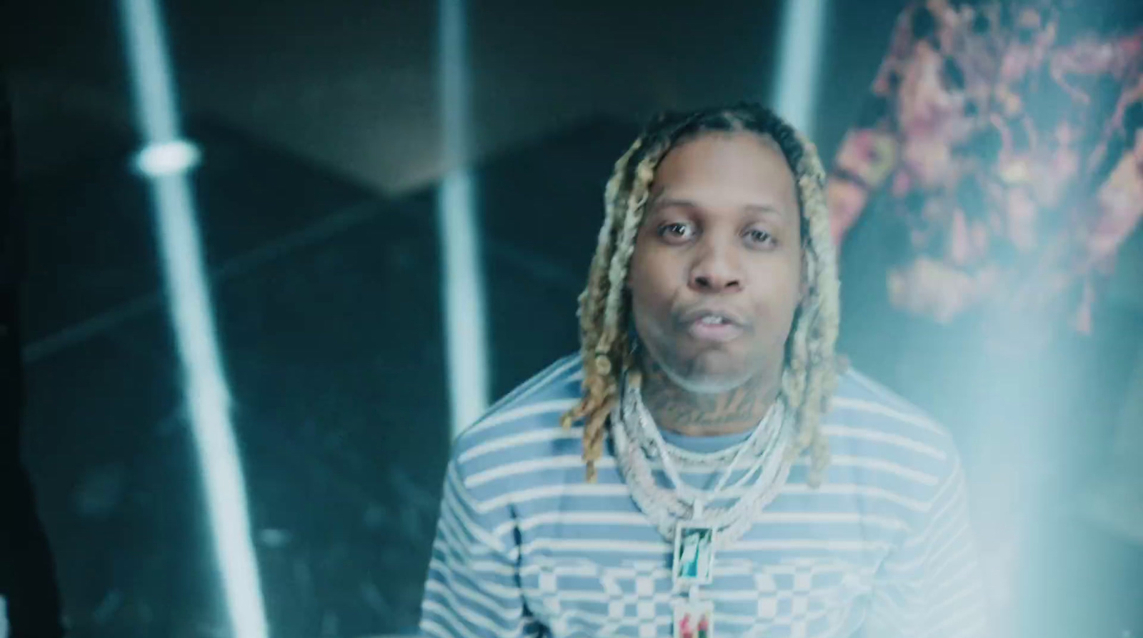 a man with dreadlocks standing in front of a mirror