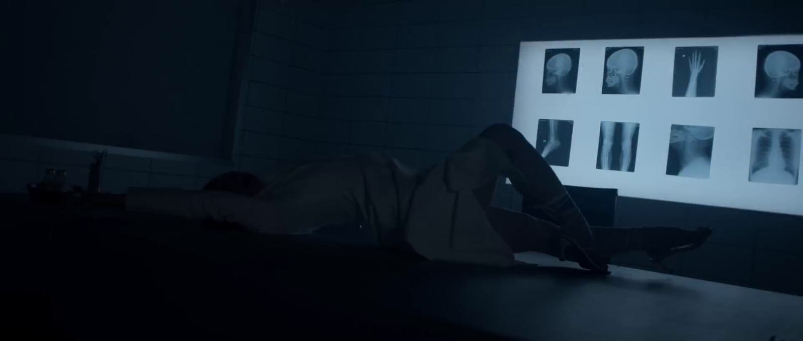 a man laying on a counter in a dark room